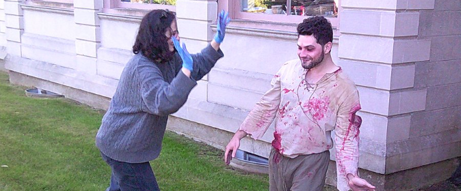 Pay No Heed cast member having his costume splattered with bloodstains.