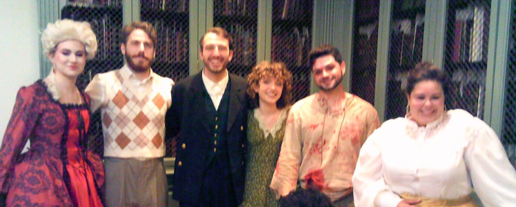 Group of Valkyrie Productions opera performers in period costumes standing in a library setting.